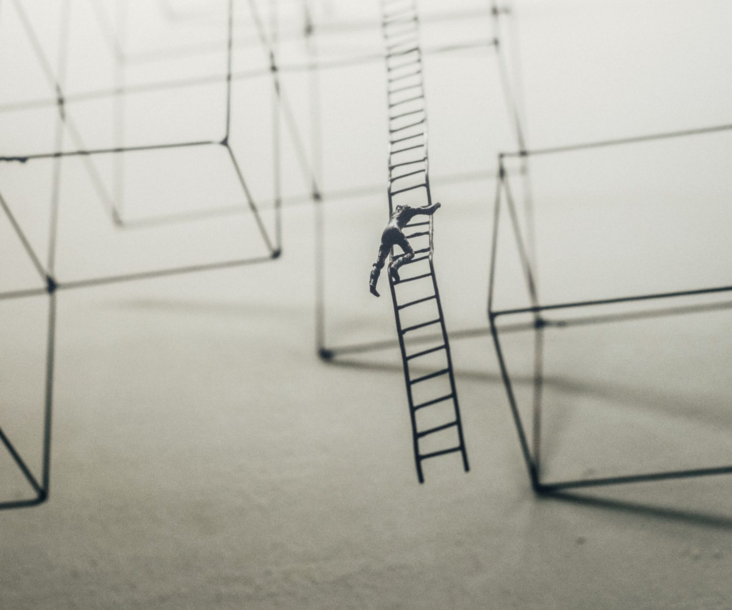 Eine Grafik eines Mannes, der auf einer unendlichen Leiter klettert, darum geometrische Formen