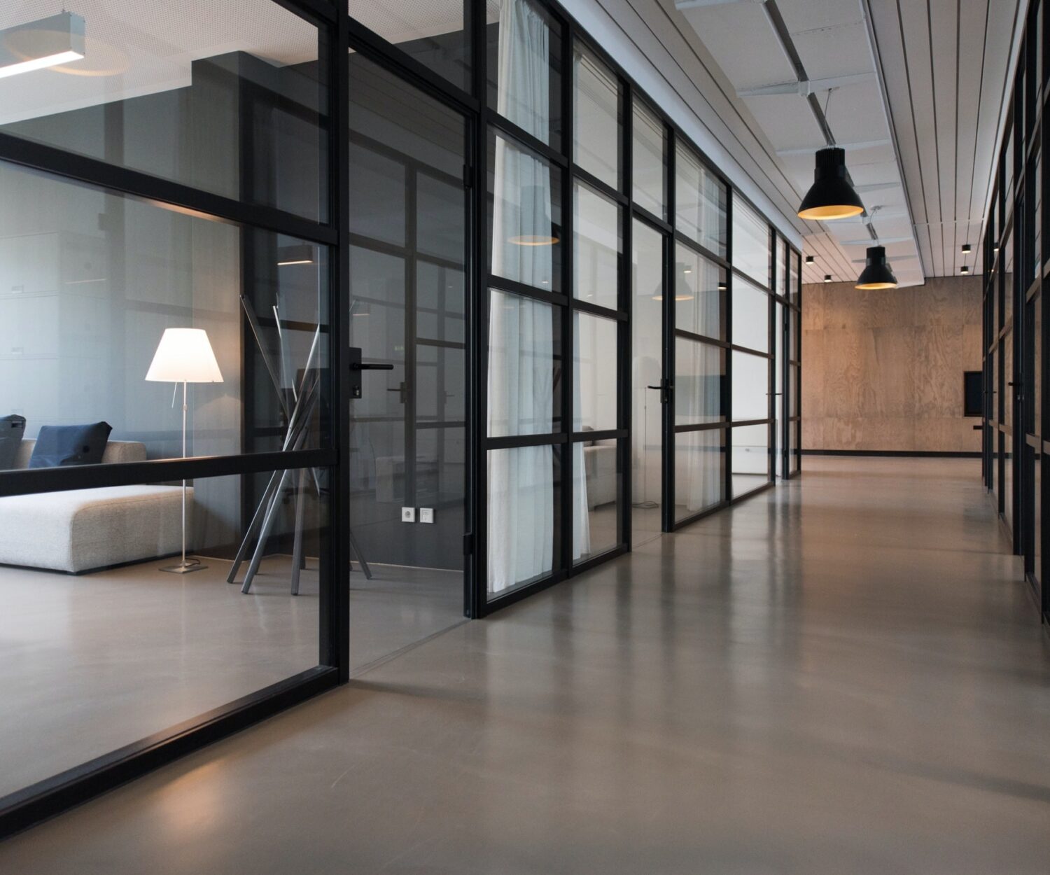 Ein modernes Büro. Blick in den Flur. Glasswände zeigen den Blick in moderne Meetingräume