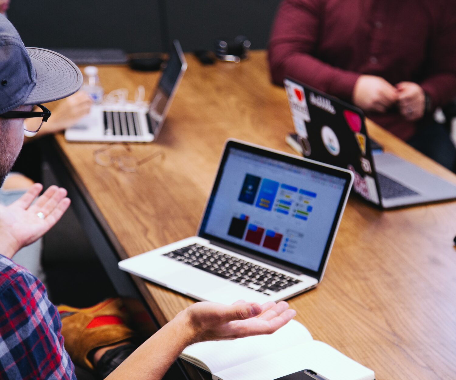 Gruppe von jungen Leuten arbeiten an einem Meetingtisch, Notebook auf dem Tisch