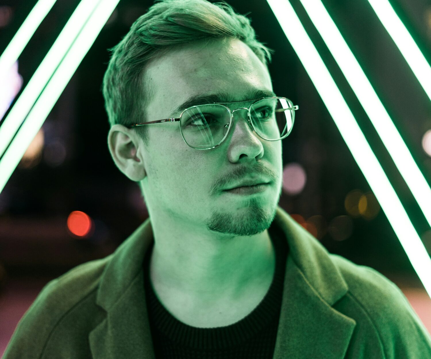 Ein man in fluoreszierendem grünen Licht schaut nach links mit ungewissem Blick