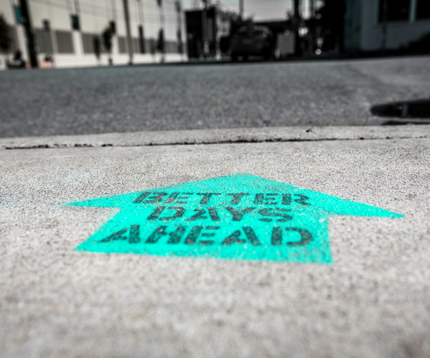 Better days ahead Aufschrift auf Pfeil auf einem Betonboden